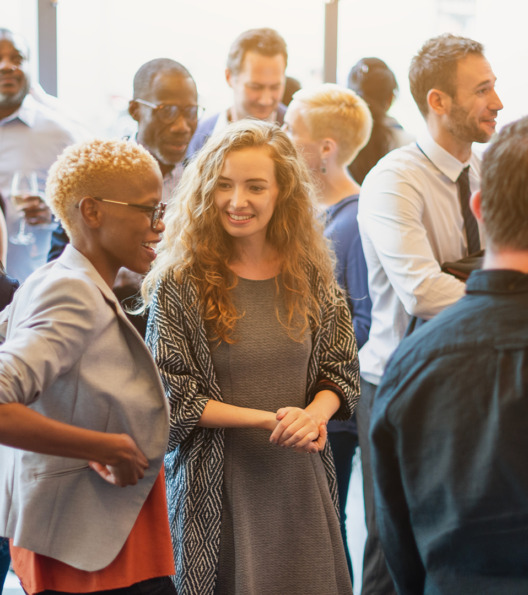 Diverse group of people socializing at a casual gathering. Men and women of various ethnicities engaged in conversation, enjoying a lively social event. Diverse people mingle at a social event.